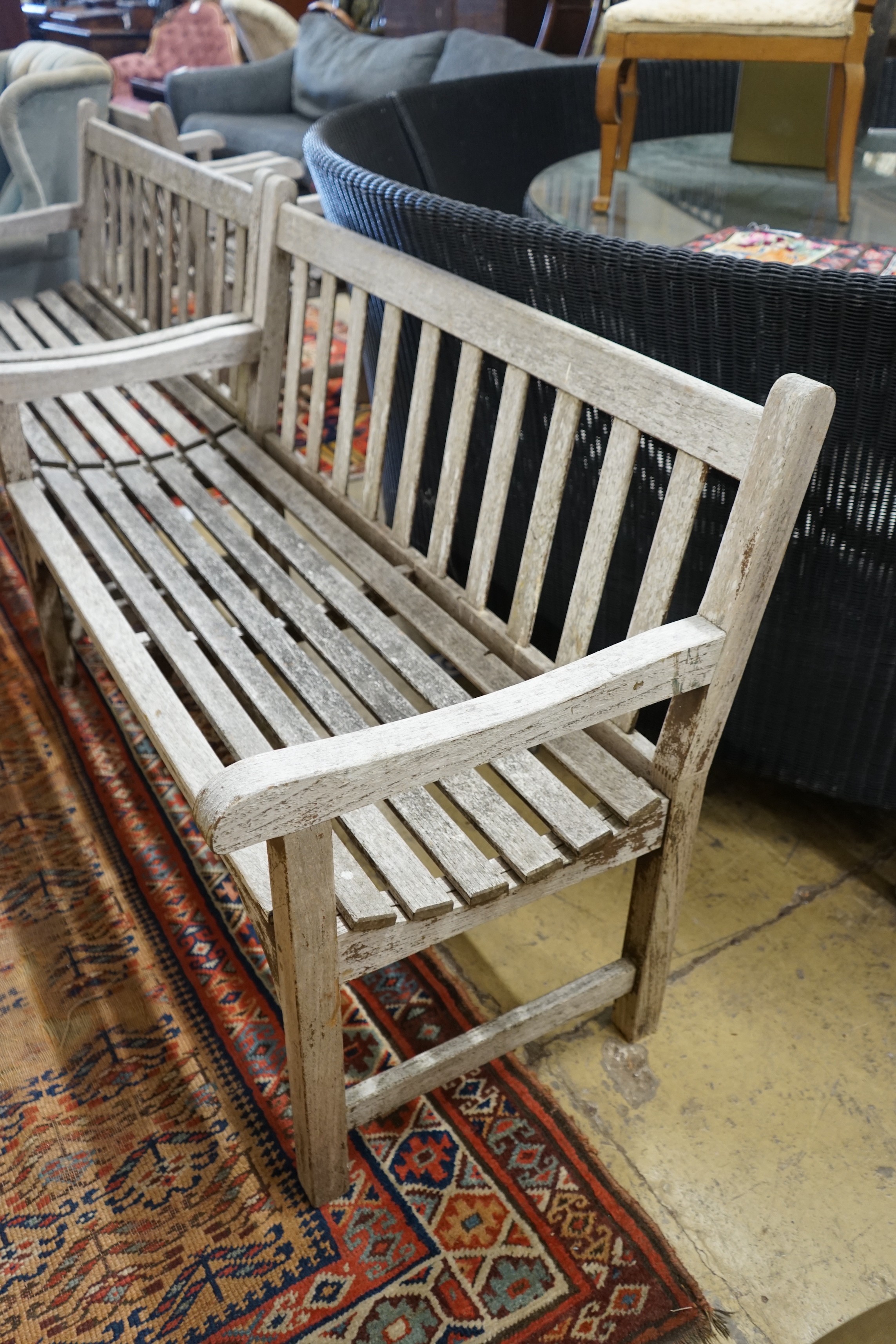 A pair of weathered teak slatted garden benches, each length 121cm, depth 56cm, height 85cm